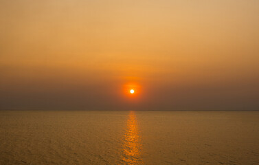 Obraz premium serene panorama image capture beauty sunset over calm ocean. sun low on horizon casting warm golden glow across sky and reflect off gentle wave. warm orange near creating peaceful calm atmosphere.