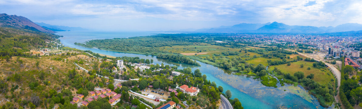 Aerial drone view of the beautiful landscape of Shiroka village beside lake at sunset near Shkoder, Albania