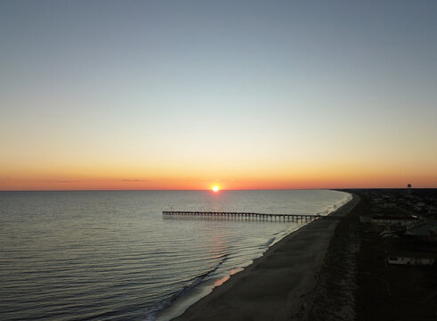 Aerial view of the ocean crest fishing pier and beach at sunset in Oak Island , Brunswick County, North Carolina