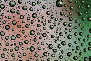 Macro shot of water droplets on blue and green gradient surface
