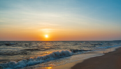 Obraz premium serene panorama image capture beauty sunset over calm ocean. sun low on horizon casting warm golden glow across sky and reflect off gentle wave. warm orange near creating peaceful calm atmosphere.