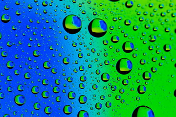 Macro shot of water droplets on blue and green gradient surface
