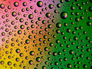 Macro shot of water droplets on blue and green gradient surface