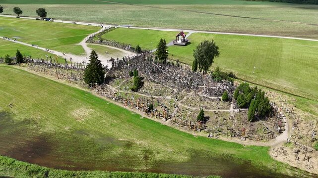 Hill of Crosses, Siauliai, Lithuania &mdash; August 1, 2025: Panoramic aerial footage captured by drone. The scene shows thousands of wooden and metal crosses, walking paths and the surrounding countryside 