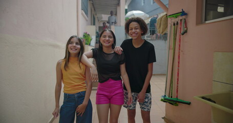 Teenagers laughing and smiling together in a suburban alleyway, enjoying carefree moments,...