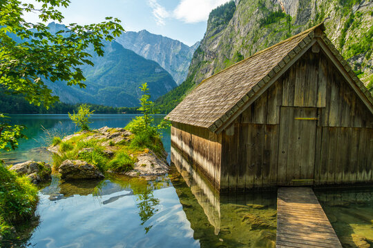 Obersee Lake, Fischunkelalm Wooden Cabin, Tree Branches and Mountains on Sunny Summer Day. Bavarian Alps. Bavaria, Germany