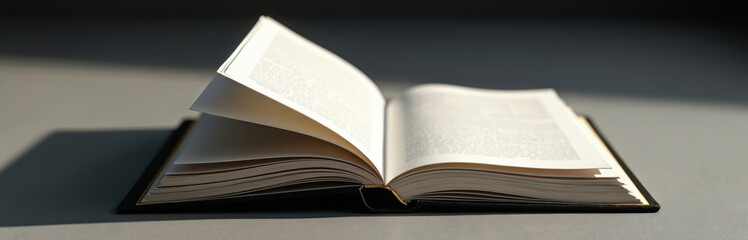 Open book placed on the table. Pages are opened. The photo illustrates studying reading and education theme. Book is a symbol of knowledge learning wisdom.