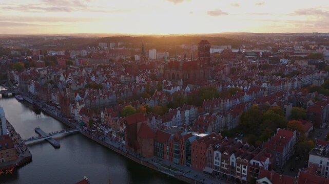 Aerial view passes Gdansks Old Town at sunset, rows of gabled roofs