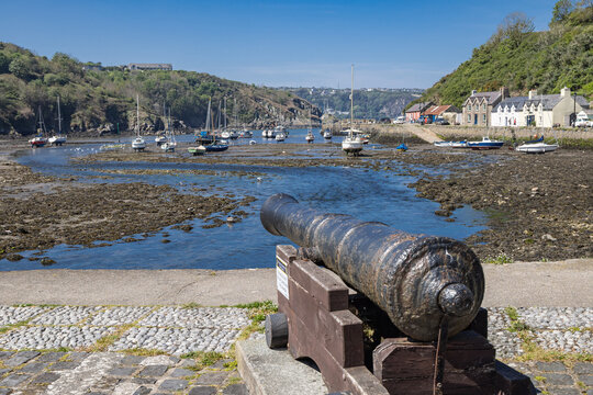 Antique cannon overlooking the harbor at Fishguard at low tide.