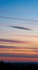 Fototapeta premium Dynamic long exposure view of soft blending clouds moving across a vast sky at twilight, creating a sense of smooth atmospheric flow ,smear ,dawn ,sunset