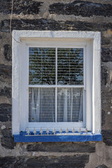 Window with a white frame in an old stone building.