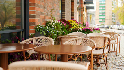 cozy outdoor cafe tables lined along cobblestone street, surrounded by colorful flower beds, inviting an atmosphere of leisurely dining in urban setting, ideal for social gatherings.