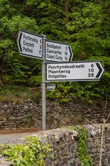 Road signs with town names and distances in Snowdonia.