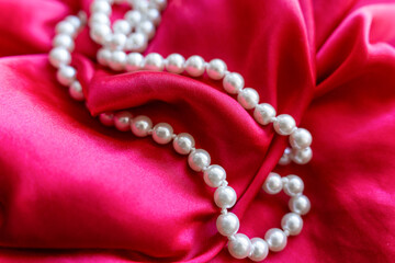 pearl beads lie on red silk