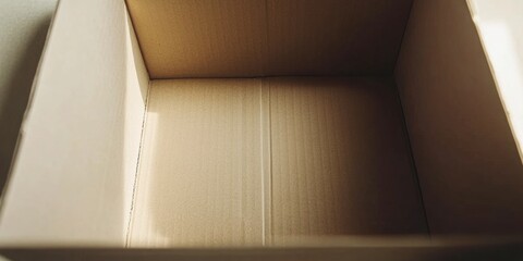 A simple brown shipping box with no contents resting on a light-colored surface