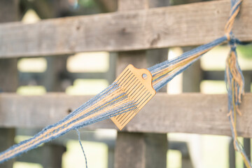 a wooden device for evenly tensioning threads while knitting them into fabric
