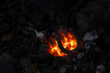 a horseshoe is heated in the fire of a blacksmith's forge
