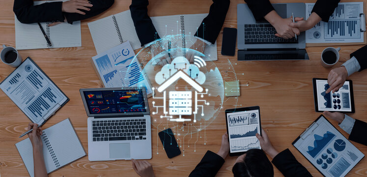 A vibrant office workspace showing teamwork and technology. Laptops and tablets display data analysis with a digital cloud graphic, emphasizing modern business collaboration and innovation. Trope