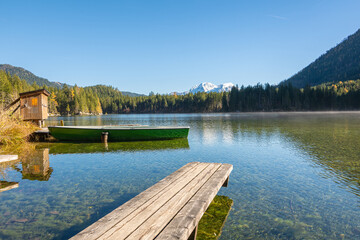 Obraz premium Boat and wooden web at the see surrounded by high mountains and forests
