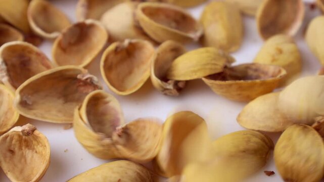 Pistachio nuts shells falling down close up