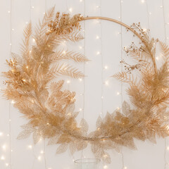 New Year's interior. A light pedestal and a golden Christmas wreath above it. Festive atmosphere.