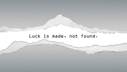 Inspirational quote “Luck is made, not found.” with torn paper texture on gray background. Motivational concept about effort, ambition, and growth mindset.