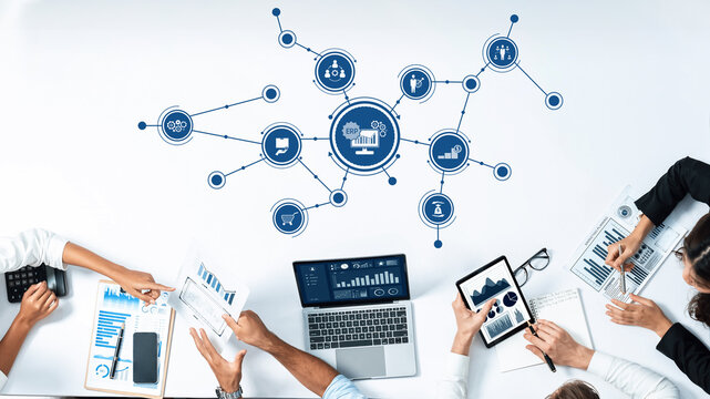 A dynamic scene depicting a collaborative business meeting where diverse professionals engage in data analysis, utilizing technology and graphic presentations to drive strategic decisions. Amity