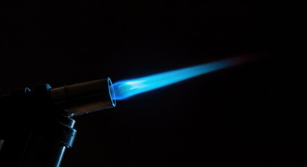 A powerful butane torch lighter displaying a bright, hot blue jet flame against a dark background, showing intense heat output ,small ,focused ,equipment