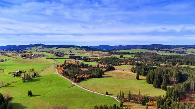Flight over the picturesque meadows and fir-tree woods with some rural areas. Wonderful scenery of nature Weitnau, a municipality in the rural district in Bavaria, Germany.