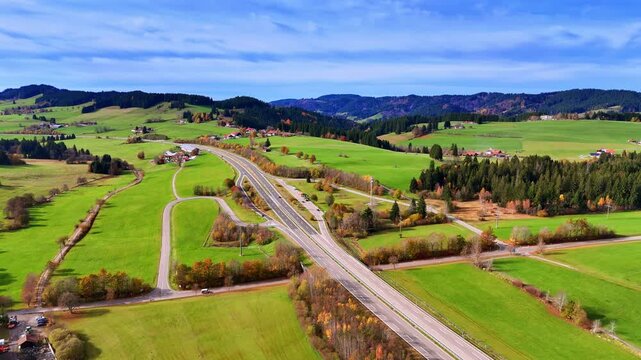 Modern roads in the beautiful rural area. Flight over fantastic meadows, some wooded lands and hills in Weitnau, Bavaria, Germany.