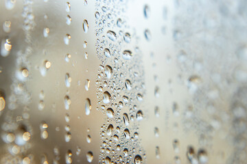 Close-up of water droplets on glass, rain streaming down the window.