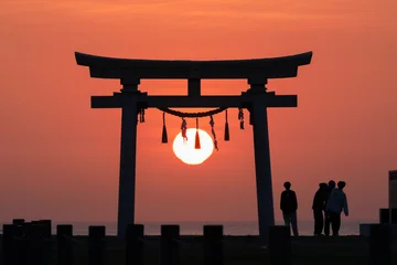 Selbstklebende Fototapeten Torii Tore 日の出を迎える青年と鳥居  © TeTsumi