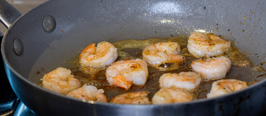 A close up look into a pan of prawns frying.