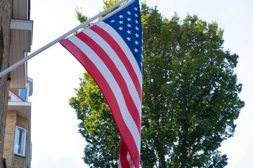 national flag of USA flutters on silk cloth against sky, 4th of July independence day concept,...