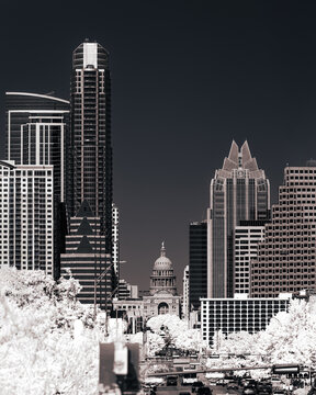 Infrared black and white view of downtown Austin, Texas, featuring the State Capitol framed by modern skyscrapers under a dramatic monochrome sky.