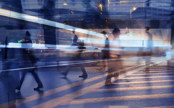business people crowd walking commuting in the city, street lights and motion blur abstract	