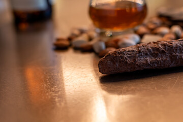 Chocolate candy close-up with blurred glass of Scotch whisky, almonds, pistachios and dried cranberries. Gourmet still life emphasizing luxury evening indulgence. Ukraine, Zhytomyr, November 7, 2025