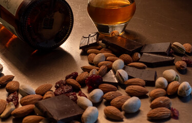 Glass of Scotch whisky paired with dark chocolate almonds pistachios and dried cranberries. Gourmet still life emphasizing luxury evening indulgence and fine taste. Ukraine, Zhytomyr, November 7, 2025