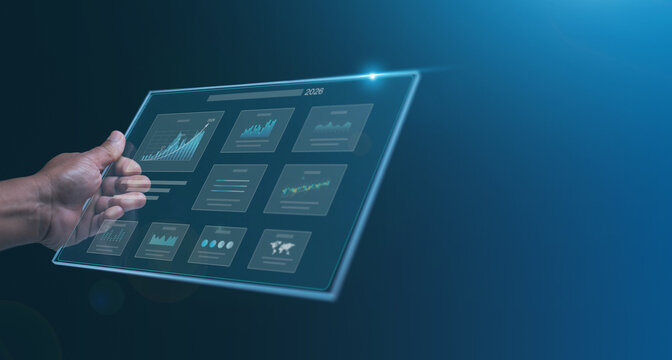 Futuristic data analytics and business intelligence concept. Hand holding digital screen displaying charts, graphs and reports for financial analysis. Strategy and technology innovation in 2026.