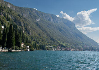 Beautiful landscape of lake Como in Varenna , Italy with green mountains, blue water and white clouds