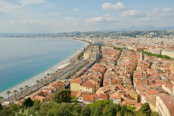 Panoramic view of Nice on French Riviera, seen from Castle Hill. Image shows Mediterranean coastline, Promenade des Anglais, historic Old Town with its terracotta rooftops. Scenic travel destination