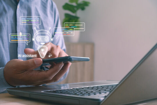 Businessman using smartphone with AI assistant chatbot on laptop for digital communication. Concept for artificial intelligence, virtual assistant technology and smart customer support automation.