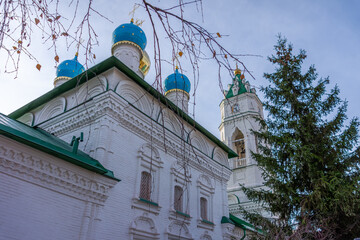 A majestic low-angle view of the white walls and blue domes of the Annunciation Church against a clear sky. A monument of 17th-century Russian architecture.