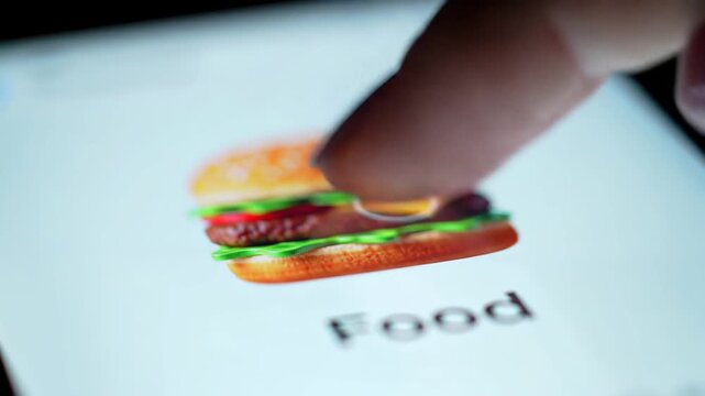 Closeup of a finger tapping on a smartphone screen displaying a hamburger icon and the word Food symbolizing online food ordering and delivery services.