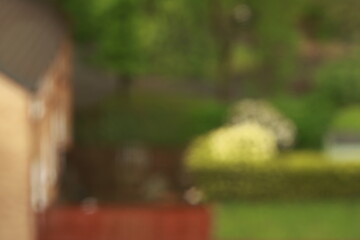 Artistic photo of raindrops on a window with a soft, blurred view of a cozy house in the background. Atmospheric and tranquil mood.