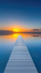 Wooden Pier Stretching Towards a Vibrant Sunset Over Calm Tropical Water Reflecting the Golden Sun and Orange Clouds Under a Deep Blue Sky