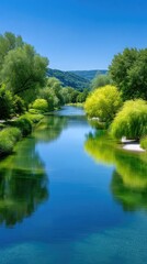 Obraz premium Serene River Reflecting Lush Green Trees Under A Clear Blue Sky On A Sunny Day