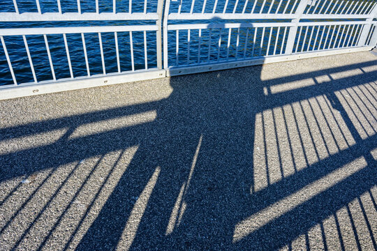 Shadows of two lovers embracing on a seaside pier