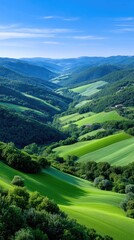 Panoramic View of Lush Green Rolling Hills and Fields Under a Bright Blue Sky with Wispy Clouds