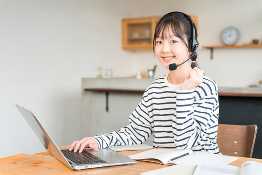 Elementary, junior high and high school students studying on a computer in the living room wearing intercoms and headsets
